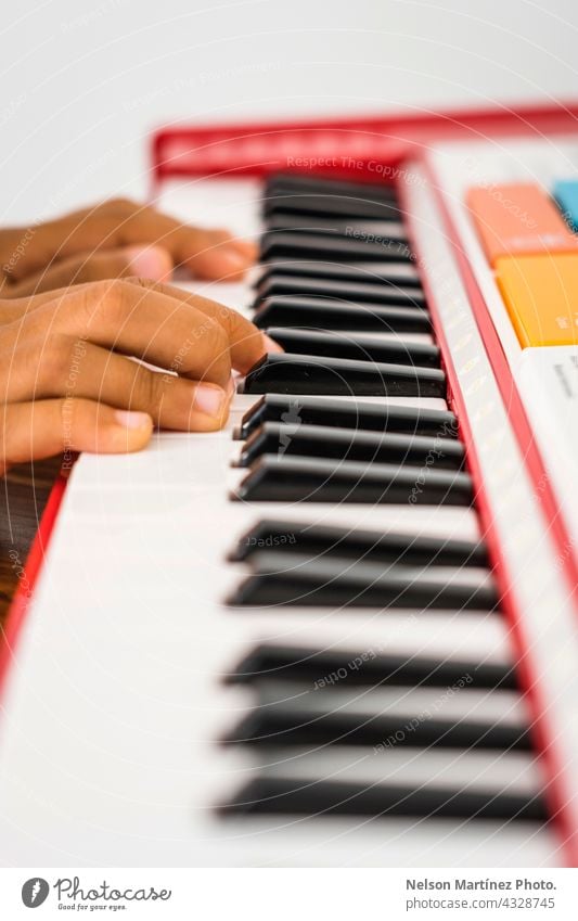 Nahaufnahme der Finger eines kleinen Kindes, das auf einem roten Klavier spielt Pianist Person Akkord Mädchen Klassik Rhythmus kreieren praktizieren klassisch