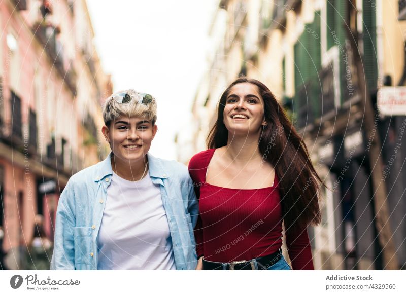 Zwei Teenager-Mädchen gehen und lächelnd auf einer Straße jung zwei Lifestyle Menschen Sommer urban Mode Frau Glück im Freien Großstadt Person schön