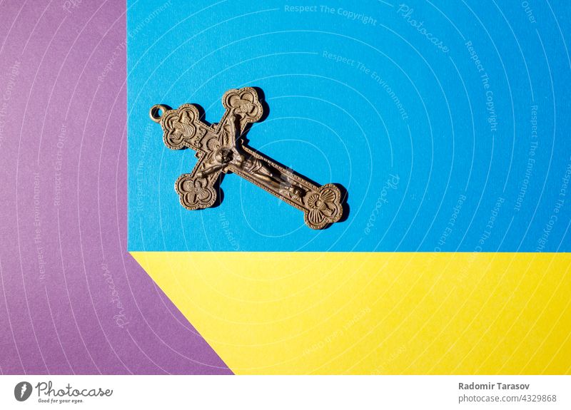 Bronzekreuz auf dem farbigen Tisch durchkreuzen alt Christentum Kruzifix Jesus religiös christian Christus Religion Gott Symbol Glaube geistig Metall
