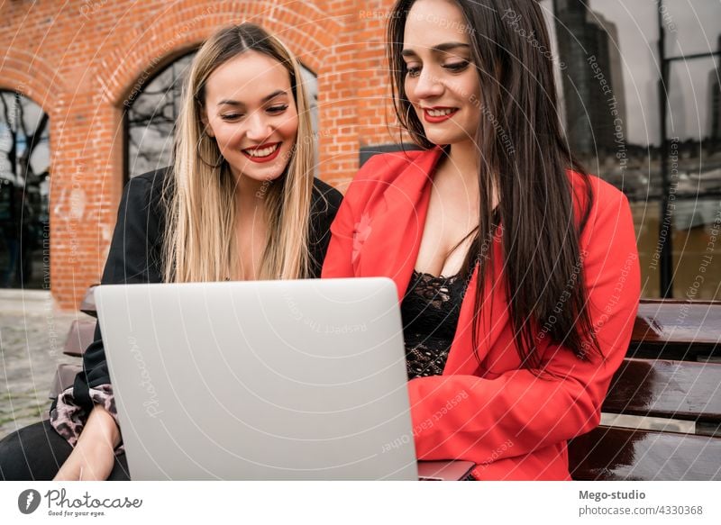 Zwei junge Freunde benutzen einen Laptop im Freien. zwei Computer Mädchen Notebook Freizeit Gerät freudig pc Anschluss Genuss Zwei Personen Gespräch online