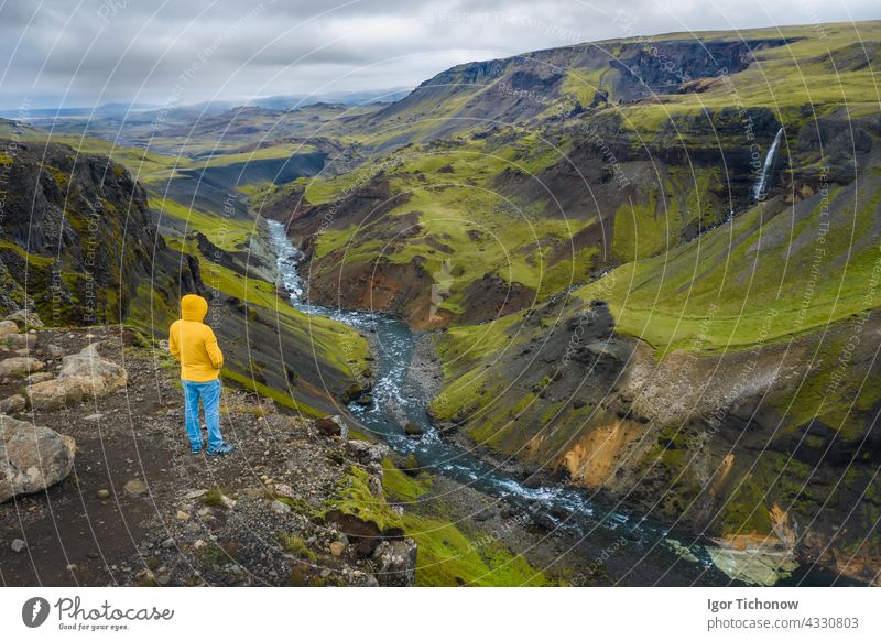 Luftaufnahme von Mann genießt Island Landschaft des Hochland-Tal und Fluss Fossa mit blauem Wasser Strom und grünen Hügeln und Moos bedeckten Klippen Antenne