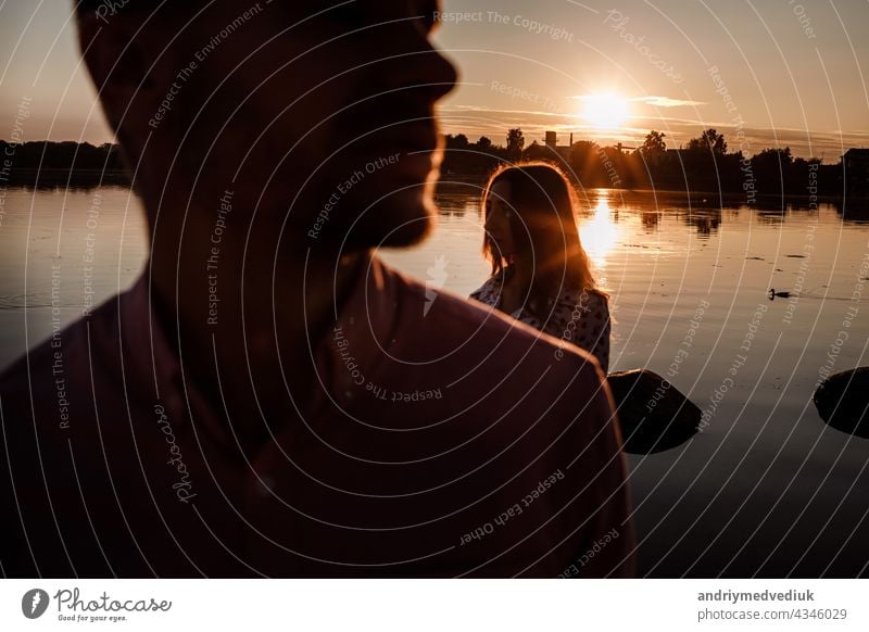 Silhouette von Paar in der Liebe in der Nähe des Sees auf Sonnenuntergang. Lovely glückliches Paar, das Spaß in der Nähe im Freien. glücklichen Urlaub Konzept. selektiven Fokus