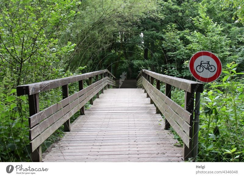 Keine Fahrräder! - Holzbrücke im Park mit Verbotsschild für Radfahrer Brücke Verkehrsschild Verbot für Radfahrer Baum Strauch Fußweg Geländer
