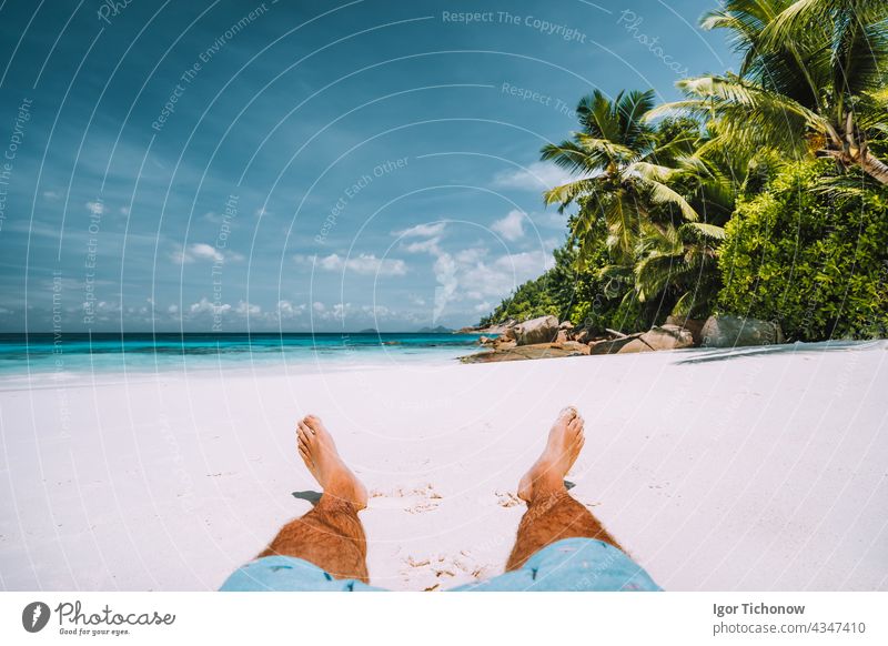 Mann ruht sich am weißen Sandstrand mit schönen Palmen aus Seychellen Strand reisen Urlaub aussruhen tropisch Sonne Sommer Erholung sich[Akk] entspannen