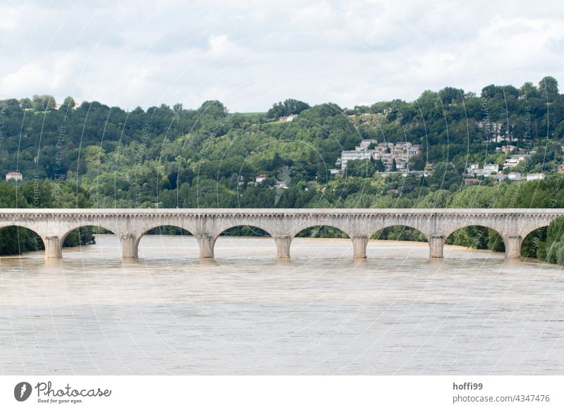 eine Bogenbrücke über einen Fluss bei Hochwasser Brücke Brückenbogen Brückenkonstruktion Brückenpfeiler Verkehrswege Architektur braunes Wasser Starkregen Regen