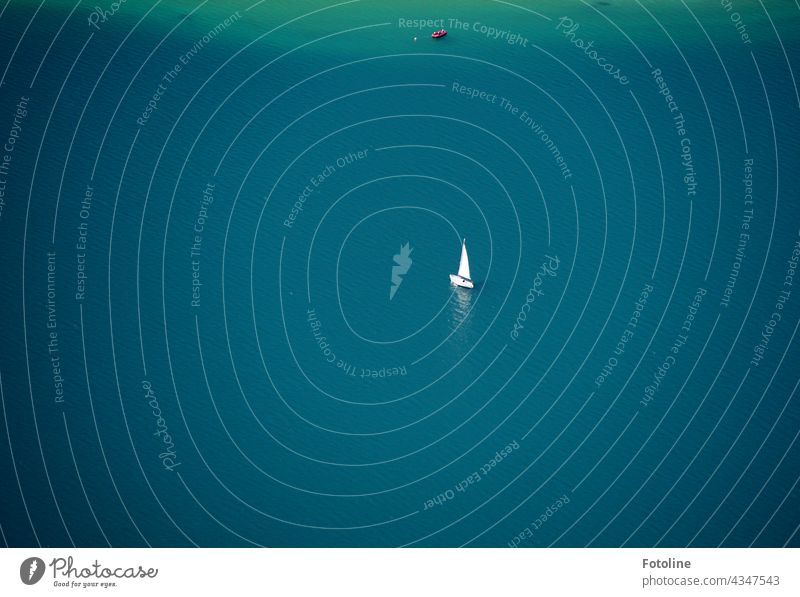 Ein kleines Segelboot segelt treibt still und einsam auf dem Achensee See Urelemente Wasser türkis blau Schiff Bootsfahrt Schifffahrt Menschenleer