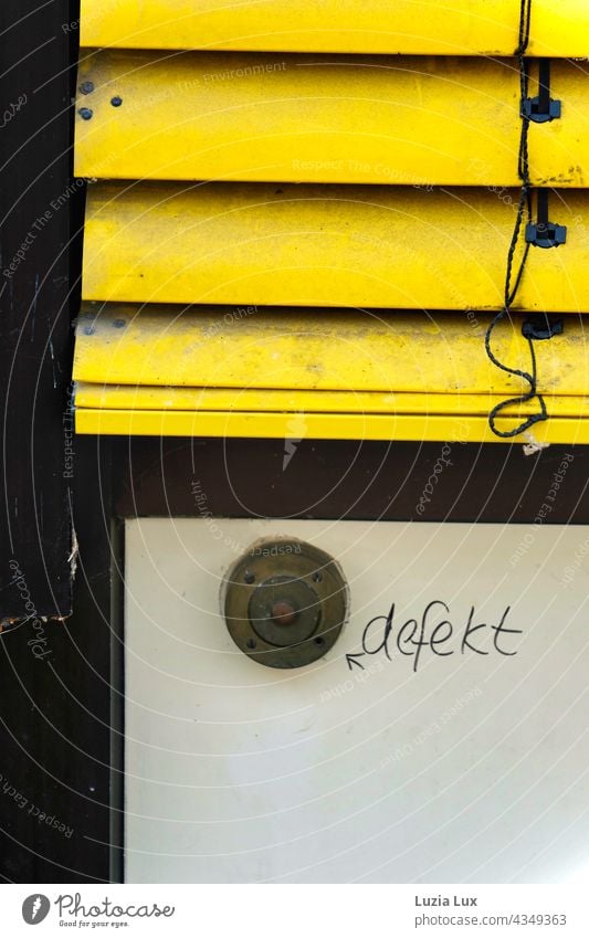 Ein alter Klingelknopf, defekt klingeln Beschriftung Hinweis kaputt Detailaufnahme Fassade Außenaufnahme Nahaufnahme trashig Vergänglichkeit gelb Rollo Jalousie