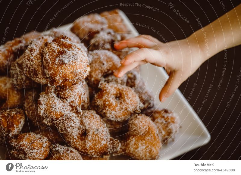 Eine Hand greift nach Pfannkuchen | Quarkbällchen | Prilleken | Krapfen | Karnevallsgebäck süß lecker Lebensmittel Dessert Ernährung Farbfoto Süßwaren Gebäck