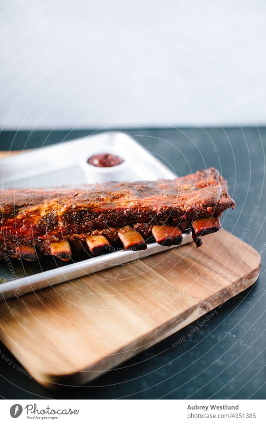 Rack of Ribs in Barbecue-Soße Amerikaner Hintergrund gebacken gegrillt grillen Rindfleisch Holzplatte Knochen Holzkohle Nahaufnahme gekocht Essen zubereiten