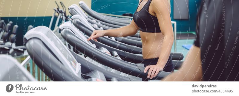 Unbekannte Frau, die das Bedienfeld eines Laufbands für das Training einstellt Panorama unkenntlich Einstellung Kontrolle Panel Maschine Fitnessstudio