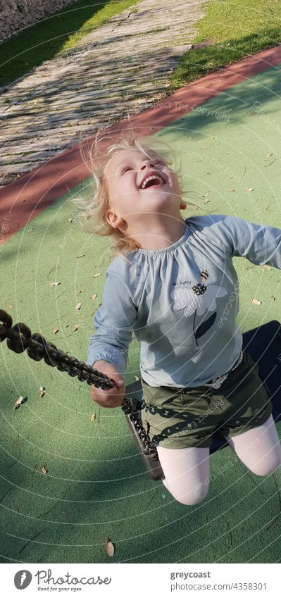 Mädchen schwingt mit Lachen und Freude pendeln Kind Spaß Kleinkind Menschen Spielplatz spielerisch im Freien lustig wenig klein Kindheit sorgenfrei nachlässig