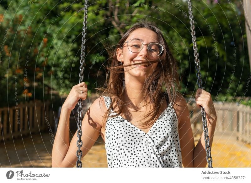 Lächelnde junge Frau beim Schwingen pendeln Spaß Park swinging Porträt Freiheit Sommer spielen Glück Person Fröhlichkeit Mädchen Freizeit Menschen Erwachsener
