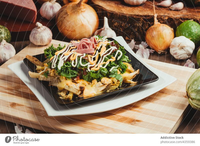 Leckere Pommes frites mit Gemüse und Schinken auf einem Teller auf dem Tisch Fastfood Salat Speise dienen Junk Food geschmackvoll Salatbeilage Lebensmittel