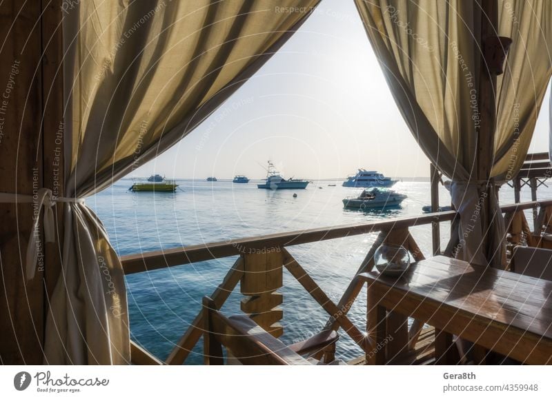 Sonnenschirme und Palmen auf dem Hintergrund des roten Meeres und Schiffe in Ägypten Hurghada Rotes Meer Sharm El Sheikh Bucht Strand blau Boot Bootsfahrt Küste