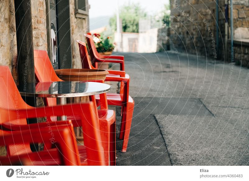 Rote Plastikstühle vor einem Café in einer italienischen Altstadt Stühle Gastronomie draußen Italien Gasse rot Straßencafé leer Terrasse Sommer Sitzgelegenheit