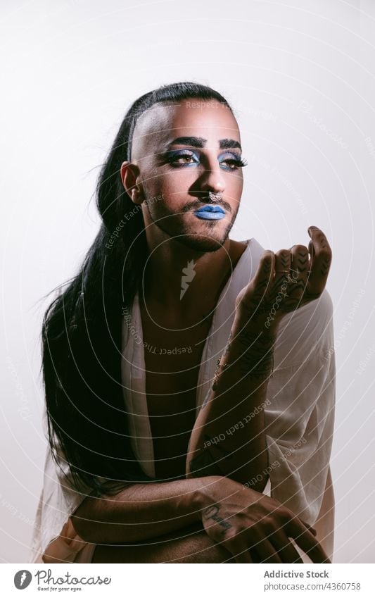 Stilvolle Transgender-Frau posiert im Studio Mann Transvestit lgbt männlich glamourös bärtig Mode transsexuell Schminke lgbtq Wegsehen Geschlecht Person feminin