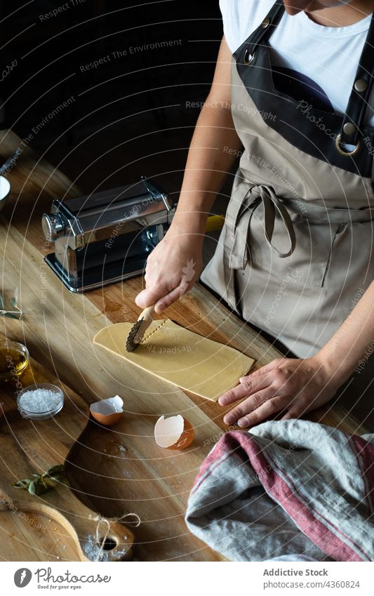 Anonyme Person bei der Zubereitung von hausgemachten Raviolis selbstgemacht Spätzle Küchenchef Essen zubereiten Lebensmittel Vorbereitung Holzplatte Nahaufnahme