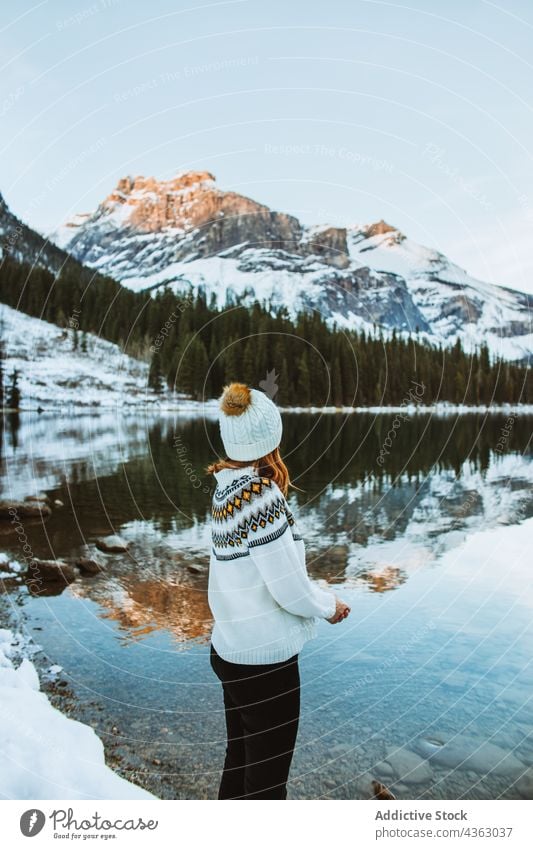 Weiblicher Reisender, der sich im Winter am Seeufer ausruht Frau Ufer ruhen Berge u. Gebirge Wald Schnee Natur nadelhaltig Smaragdsee British Columbia Kanada