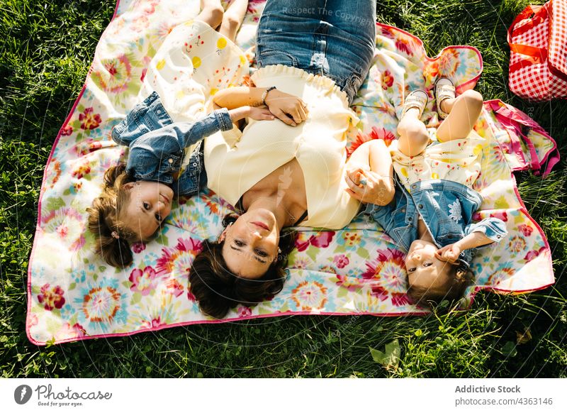 Kleine Geschwister mit Mama auf einer Decke im Park liegend Mutter Kind Zusammensein Glück Sommer Geschwisterkind Liebe Tochter ähnlich niedlich Partnerschaft