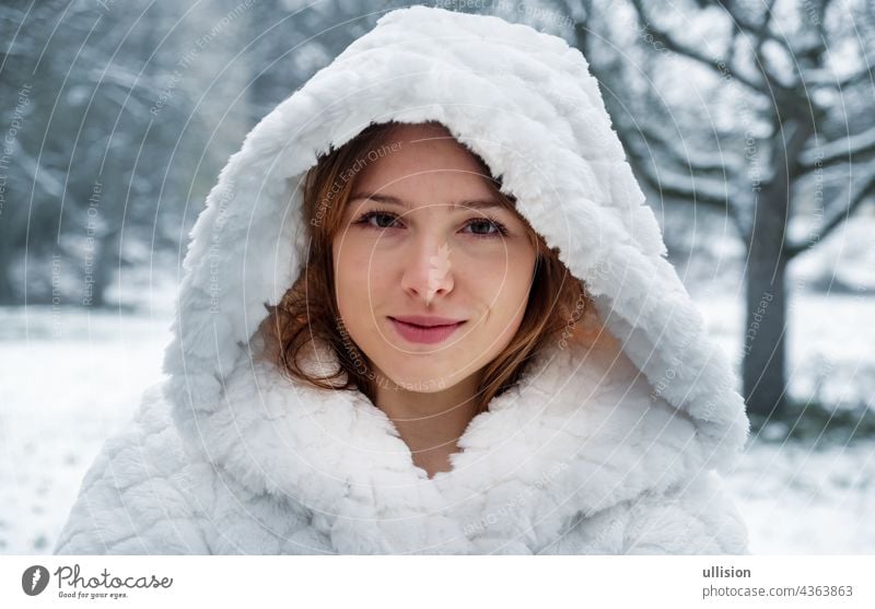 Porträt eines schönen niedlichen sexy verführerische junge Mädchen draußen in der Natur im kalten Winter mit weißem Mantel und Kapuze Glück warm Frau Lippen