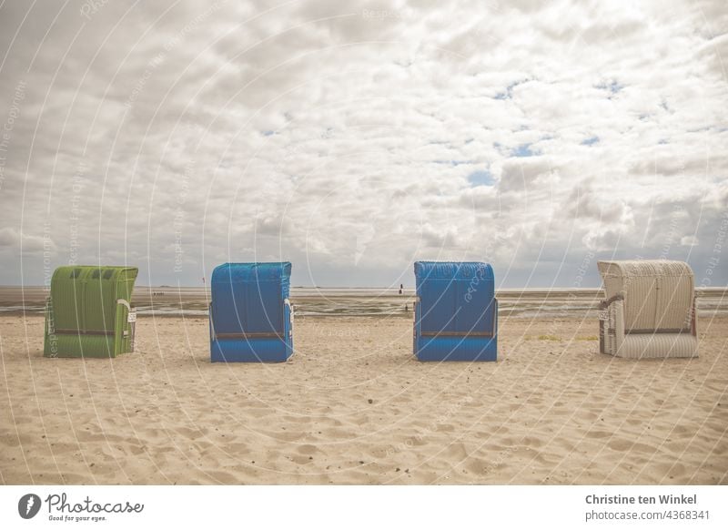 Vier Strandkörbe stehen bei trübem Wetter und Niedrigwasser am leeren Strand und warten auf Gäste Strandkorb Ruhe Nordseestrand menschenleer Sommer Sand