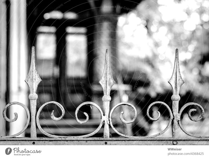 Ein verwunschenes, vielleicht längst verlassenes Haus hinter einem  kunstvoll geschmiedeten Zaun - ein lizenzfreies Stock Foto von Photocase