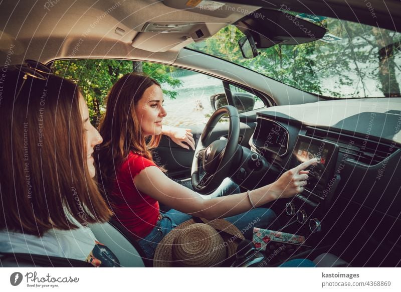 Zwei junge Mädchen hören gute Musik, während sie im Auto fahren