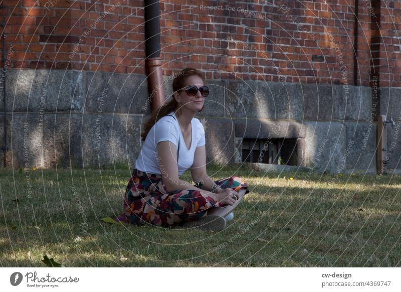 sitzende Frau vor einer Kirche Kirchplatz Außenaufnahme Farbfoto