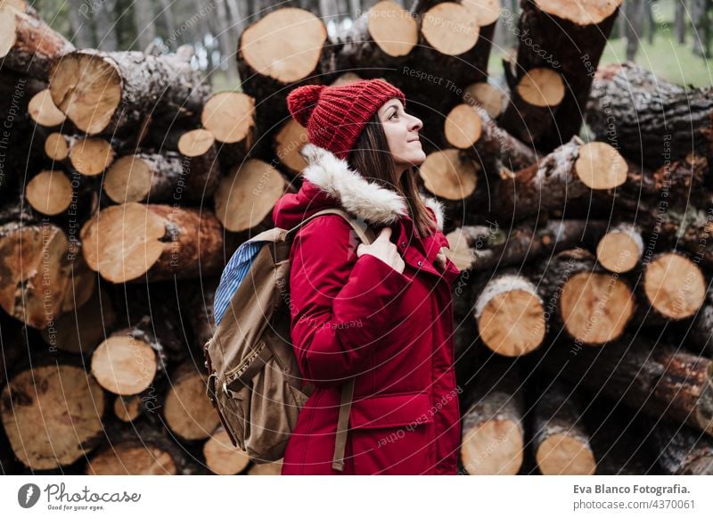 Backpacker Frau vor Holzstämmen in den Bergen. Herbst- oder Winterzeit. Natur und Lebensstil wandern Berge u. Gebirge Kaukasier Wald kalt Mantel Hut Camping