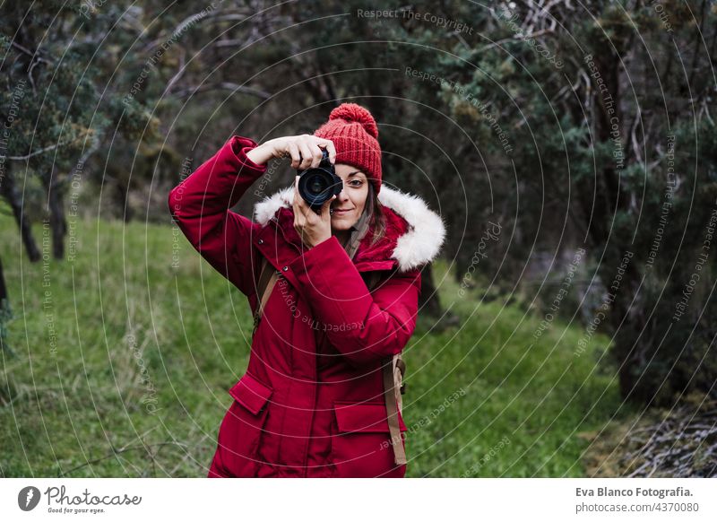 Backpacker kaukasische Frau, die Bild mit der Kamera im Wald im Winter oder Herbst Saison. Lebensstil und Natur Fotokamera reflektorisch Fotograf wandern