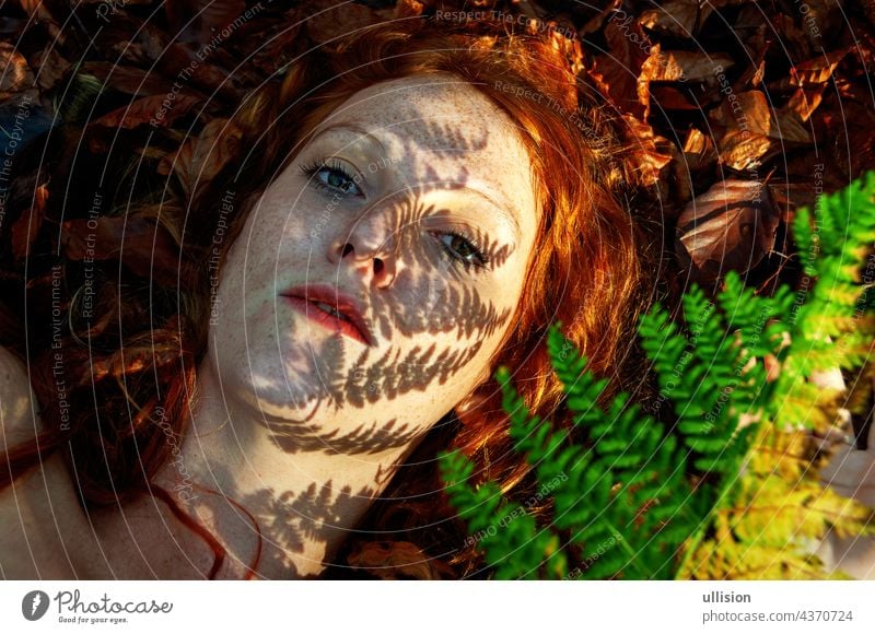 schönes Porträt eines jungen verführerischen fuchsigen Mädchens im Herbst, mit Schatten des Farnwedels im Gesicht, schöne sexy attraktive rothaarige Frau