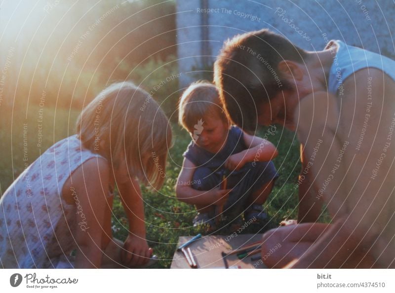 Konstruktiv l Mutter malt mit zwei Kindern im Garten im Sonnenuntergang. Mutterschaft Liebe Kindheit Lifestyle Menschen Frau Zusammensein Fröhlichkeit Glück