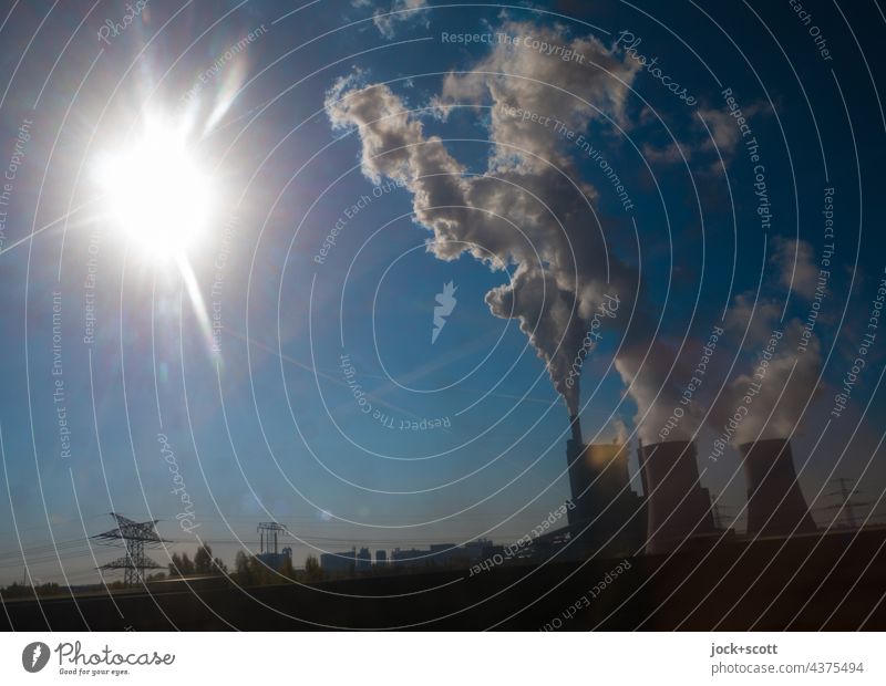 Kraftwerk im Gegenlicht mit viel Ausstoß von CO2-Emissionen Energiewirtschaft Industrie Sonne Schornstein Umweltverschmutzung Luftverschmutzung Strommast