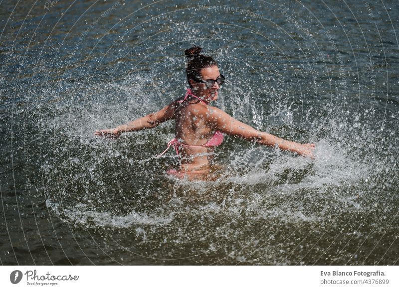 glückliche kaukasische frau, die im see schwimmt und plantscht. sommerzeit. spaß im freien Kaukasier Frau Schwimmsport See Sommer Spaß Glück platschen