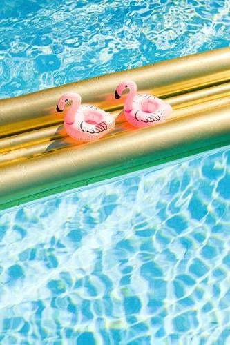 Zwei aufblasbare Flamingos genießen auf einer goldenen Luftmatratze in kristallklarem Wasser ihre Mittagspause Urlaub Pause Freunde Paar Paarurlaub Sommerurlaub