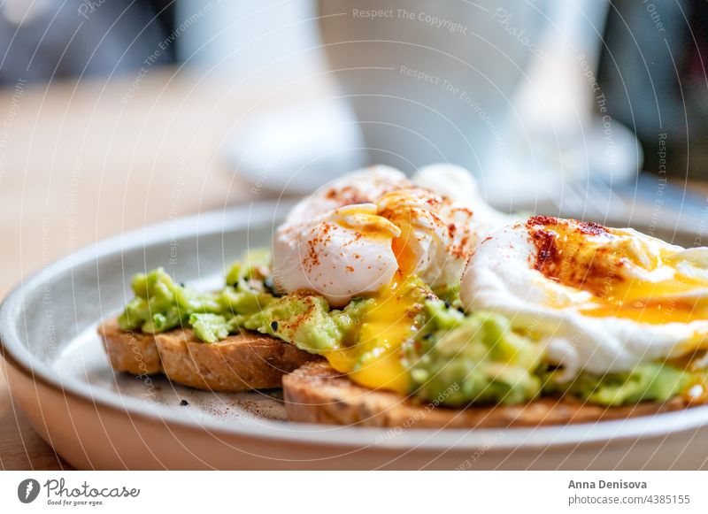 Toast und pochierte Eier Zuprosten Avocado Vegetarier Gesundheit Lebensmittel Eigelb Belegtes Brot Frühstück lecker pochiertes Ei auf Toast geschmackvoll
