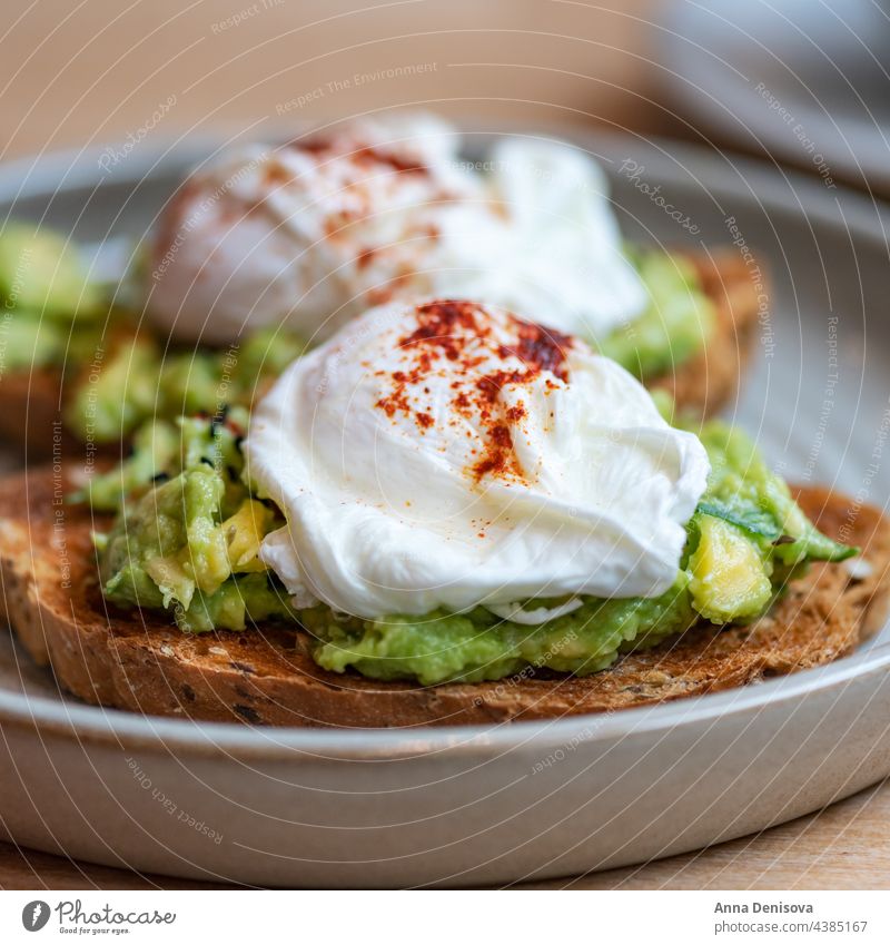 Toast und pochierte Eier Zuprosten Avocado Vegetarier Gesundheit Lebensmittel Eigelb Belegtes Brot Frühstück lecker pochiertes Ei auf Toast geschmackvoll