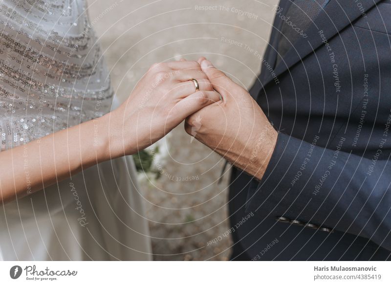 Hochzeitspaar, das sich an den Händen hält und den Ring anlegt, Nahaufnahme Erwachsener schön hochzeitlich Braut Pflege Feier Festakt abschließen Paar Kleid
