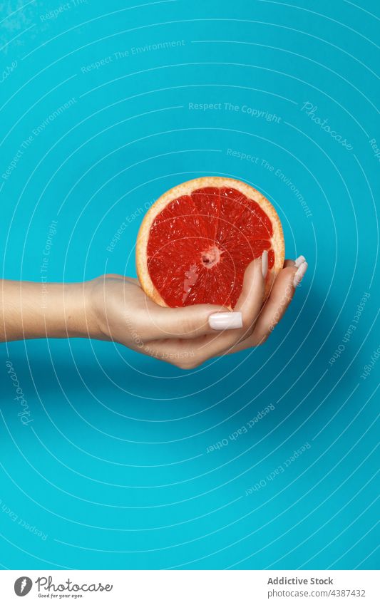 Frau mit Grapefruit in der Hand Frucht Hälfte Scheibe frisch natürlich Saft Gesundheit Zitrusfrüchte Vitamin reif organisch Lebensmittel tropisch rot