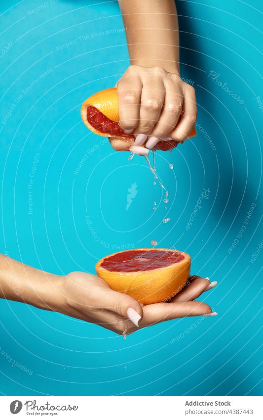 Frau drückt frische saftige Grapefruit aus Hand drücken Saft Frucht Hälfte natürlich Gesundheit Zitrusfrüchte Vitamin reif organisch Lebensmittel tropisch rot
