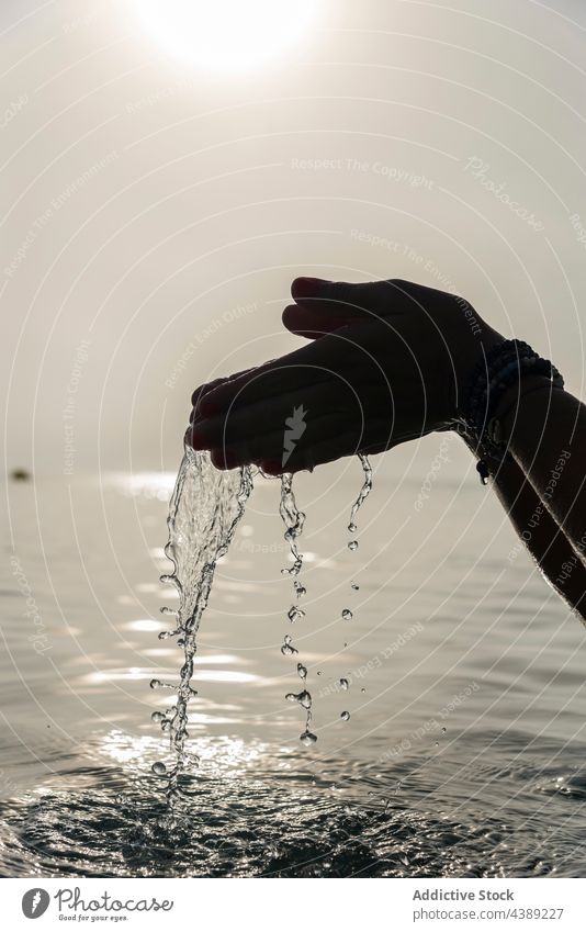 Crop-Frau mit einer Handvoll Wasser im Meer MEER Tropfen Tröpfchen Morgen nass Sonnenlicht frisch Playa de Muro Alcudia Mallorca Spanien Harmonie Windstille