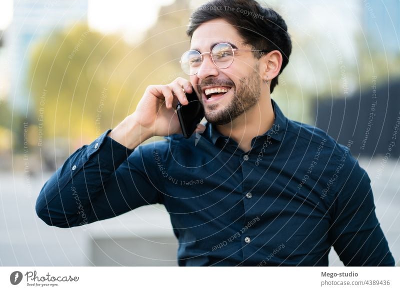 Junger Mann beim Telefonieren im Freien. jung Mobile urban Lächeln Anschluss Apparatur Porträt positiv Drahtlos Beteiligung laufen Blick Tippen sprechend reden