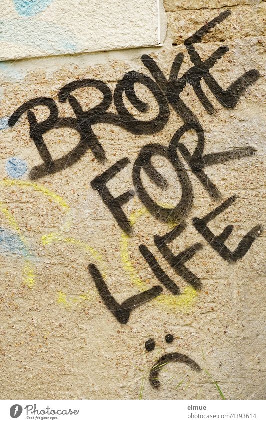 BROKE FOR LIFE steht in schwarzen Großbuchstaben an der beigefarbenen, besprayten Wand / fürs Leben pleite broke for life Graffito Graffiti Farbe Wort verputzt