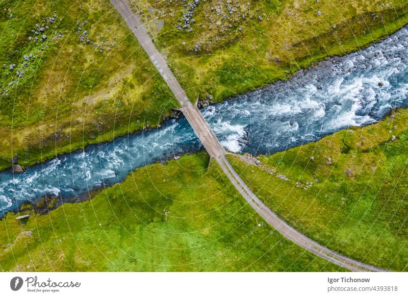 Luftaufnahme von oben auf einen milchig blauen Fluss und eine Brücke, Island Antenne abgelegen Felsen Landschaft Draufsicht Park Tourismus reisen Baum