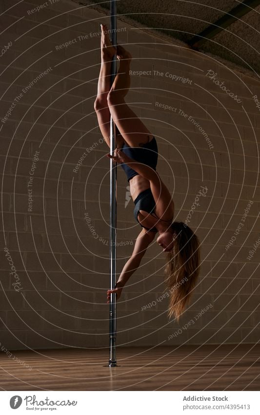 Pole-Tänzerin beim Handstand im Studio Frau Tanzen Mast beweglich Probe Anmut Atelier gymnastisch Pylon akrobatisch auf den Kopf gestellt üben ausführen Dehnung