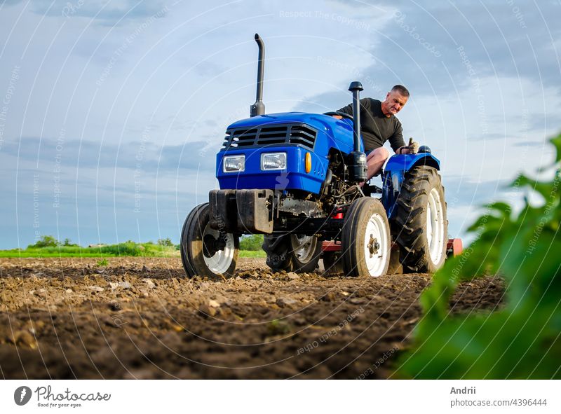 Ein Landwirt arbeitet mit einem Traktor auf dem Feld. Fräsen des Bodens, Zerkleinern und Auflockern des Bodens vor dem Schneiden der Reihen. Ackerbau, Landwirtschaft. Vorbereitende Erdarbeiten vor der Aussaat einer neuen Kultur. Bodenbearbeitung