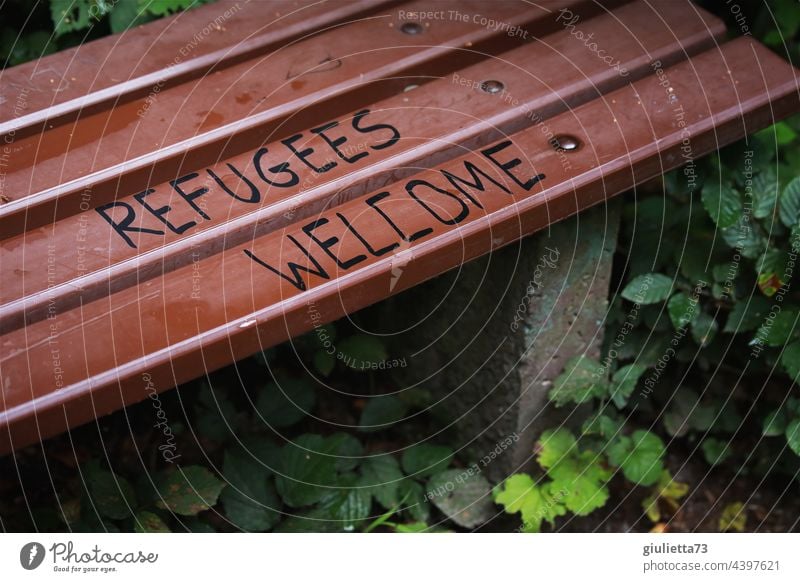 Refugees welcome - Flüchtlinge willkommen | Schriftzug auf einer Bank Graffiti Willkommen Park Außenaufnahme Schriftzeichen Menschenleer Farbfoto