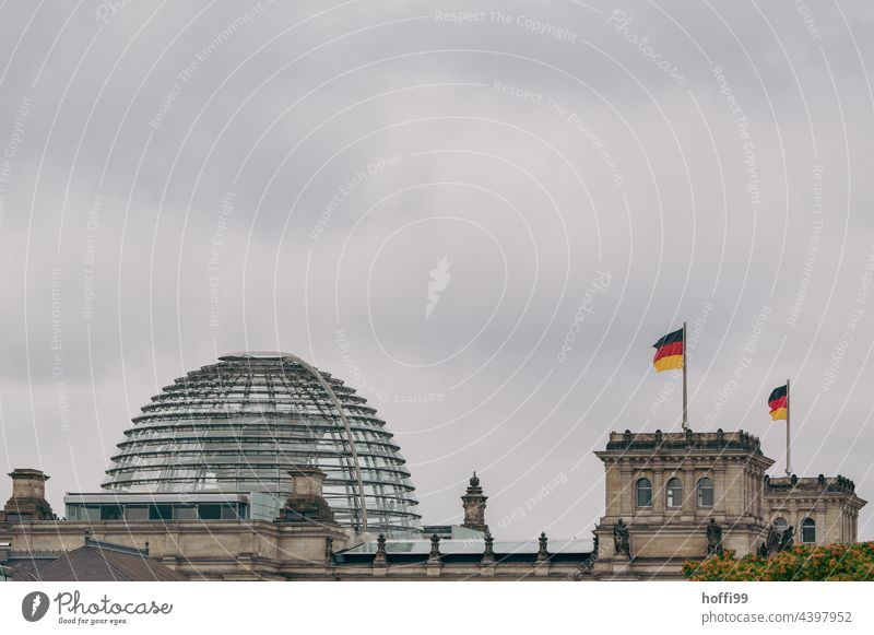 Deutschlandfahne auf dem Reichstag in Berlin bei aufkommendem Unwetter - stürmische Zeiten schwarz-rot-gold Fahne wehen Politik & Staat Wahrzeichen Falte gelb
