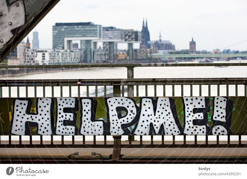 Hilf mir. Graffiti auf einer Eisenbahnbrücke in Köln, im Hintergrund, der Rhein, der Kölner Dom und die Kranhäuser Hilferuf hilfsbedürftig Hilfesuchend