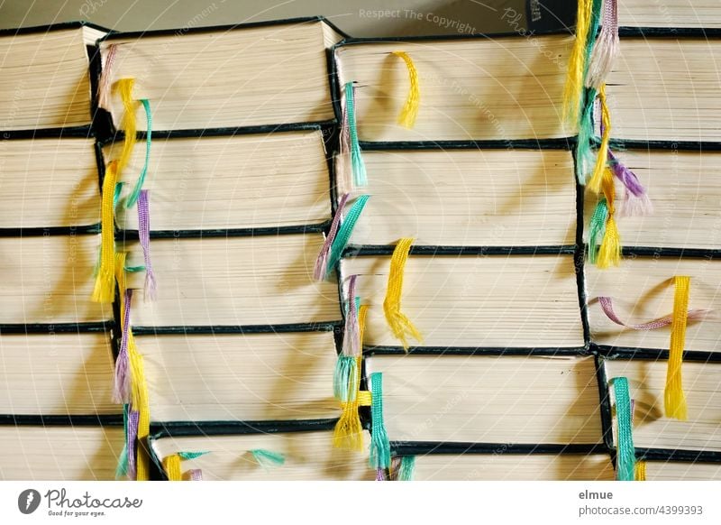 Seitenansicht mehrerer Stapel gleicher Bücher mit bunten Lesebändern / lesen / Bildung Buch Leseband Lesebändchen Bibel Nachschlagewerk Ansammlung Farbe